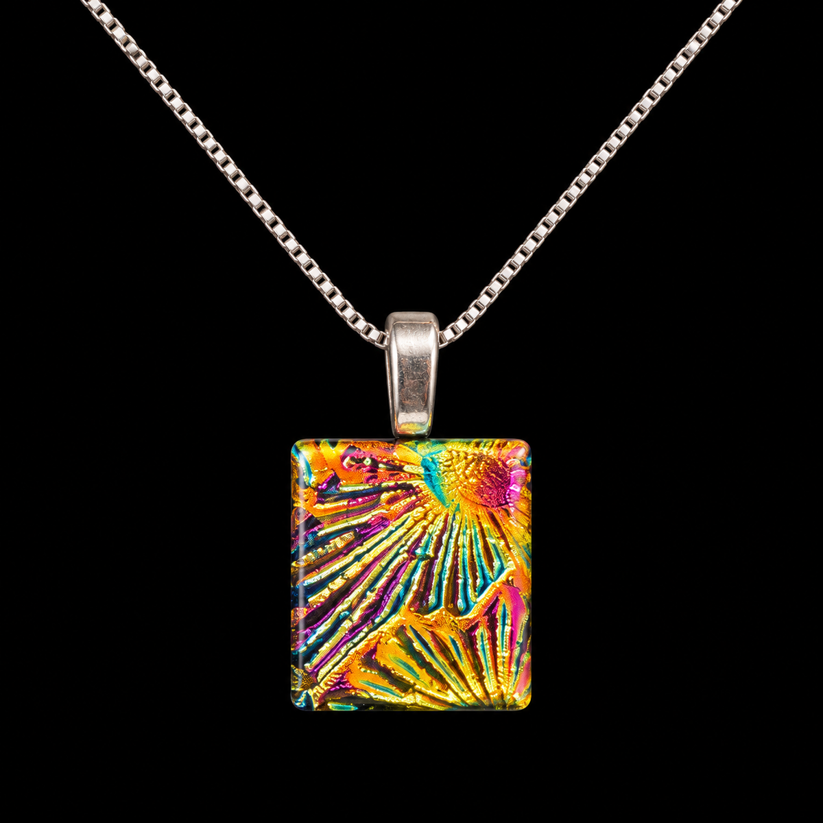 A silver chain necklace with a square pendant featuring a vibrant, multicolored abstract pattern of radiating lines in yellow, orange, pink, and blue, set against a solid black background.