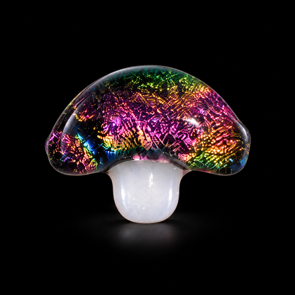 A mushroom-shaped glass art piece with a vibrant, iridescent rainbow pattern on the cap and a smooth, milky white stem, set against a solid black background.